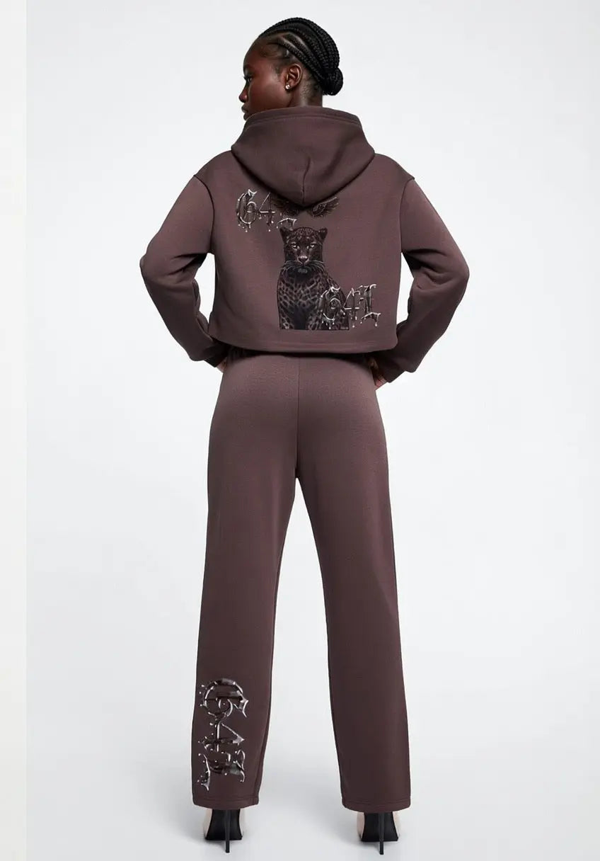 Back view of model wearing dark reddish purple cropped zip-up hoodie with graphic design on back