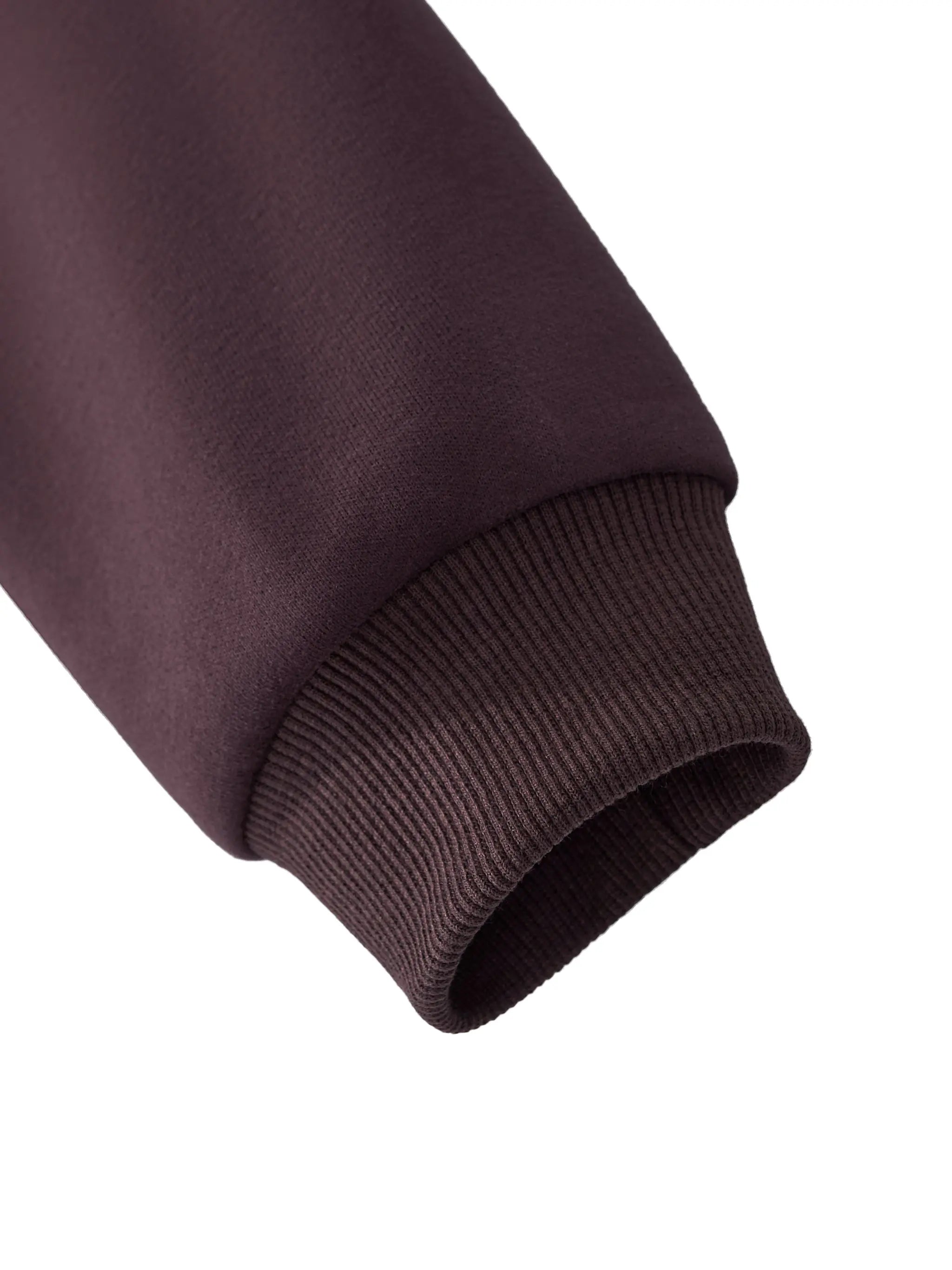 Close-up of ribbed cuff on sleeve of dark reddish purple cropped zip-up hoodie by ODMPOD