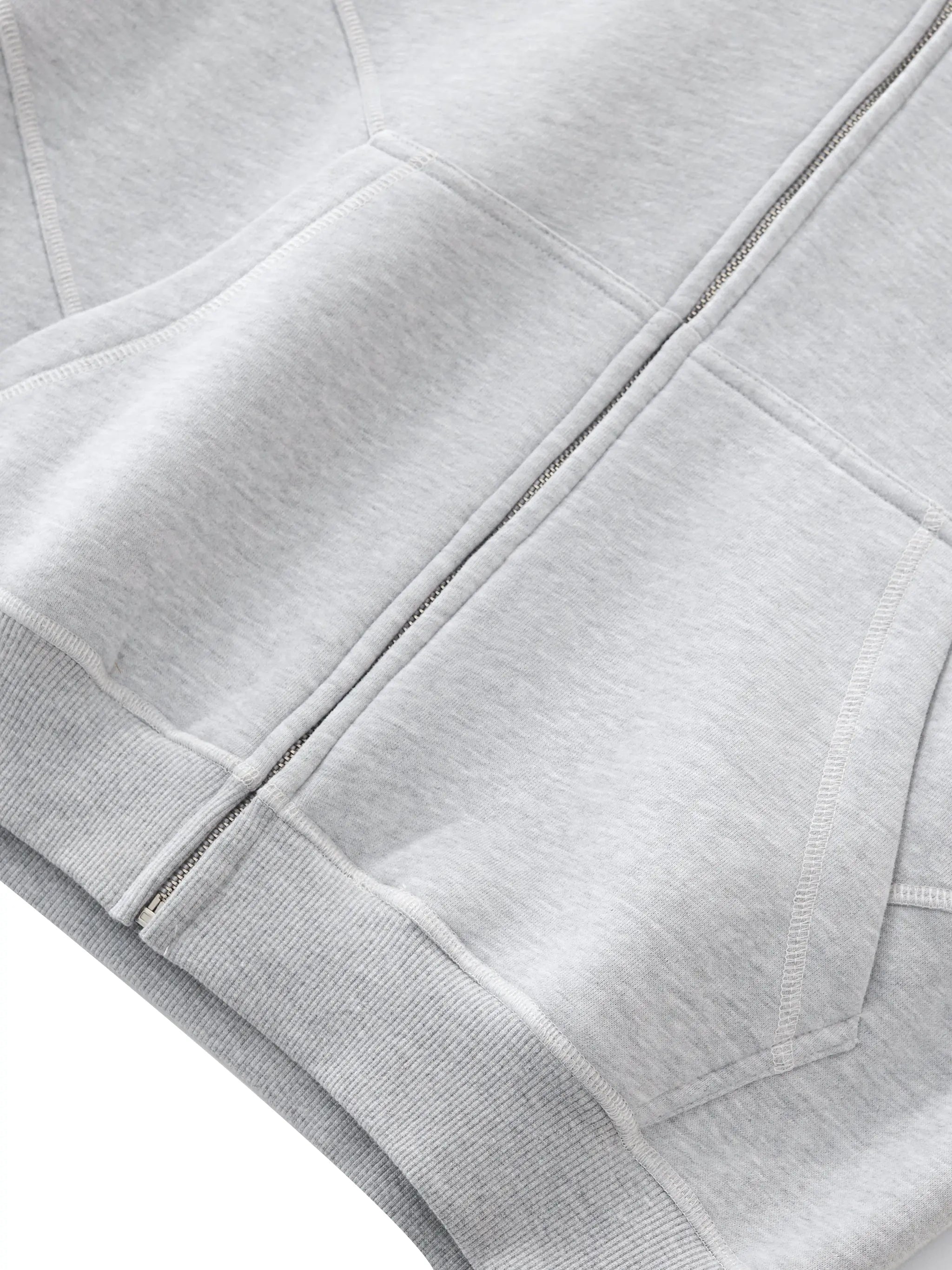 Close-up of ODMPOD gray contrast stitch fleece zip hoodie showing front pockets and zipper details